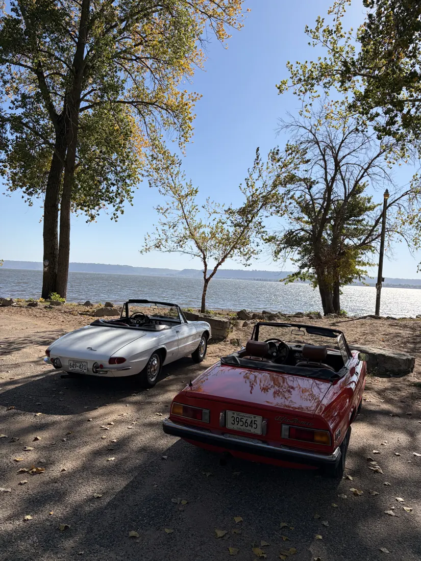 Classic sports cars gathered beside a Minnesota lake